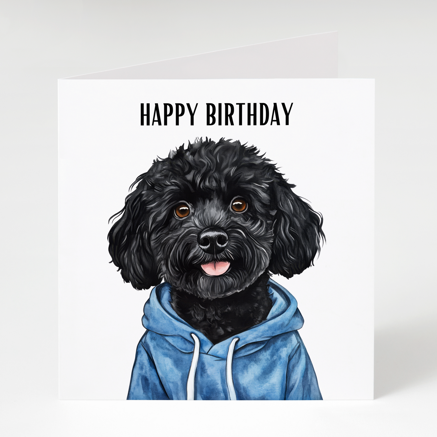 Cute Black Cockapoo wearing a hoodie on a colourful birthday card, perfect for Black Cockapoo owners, dog lovers, and birthday celebrations.