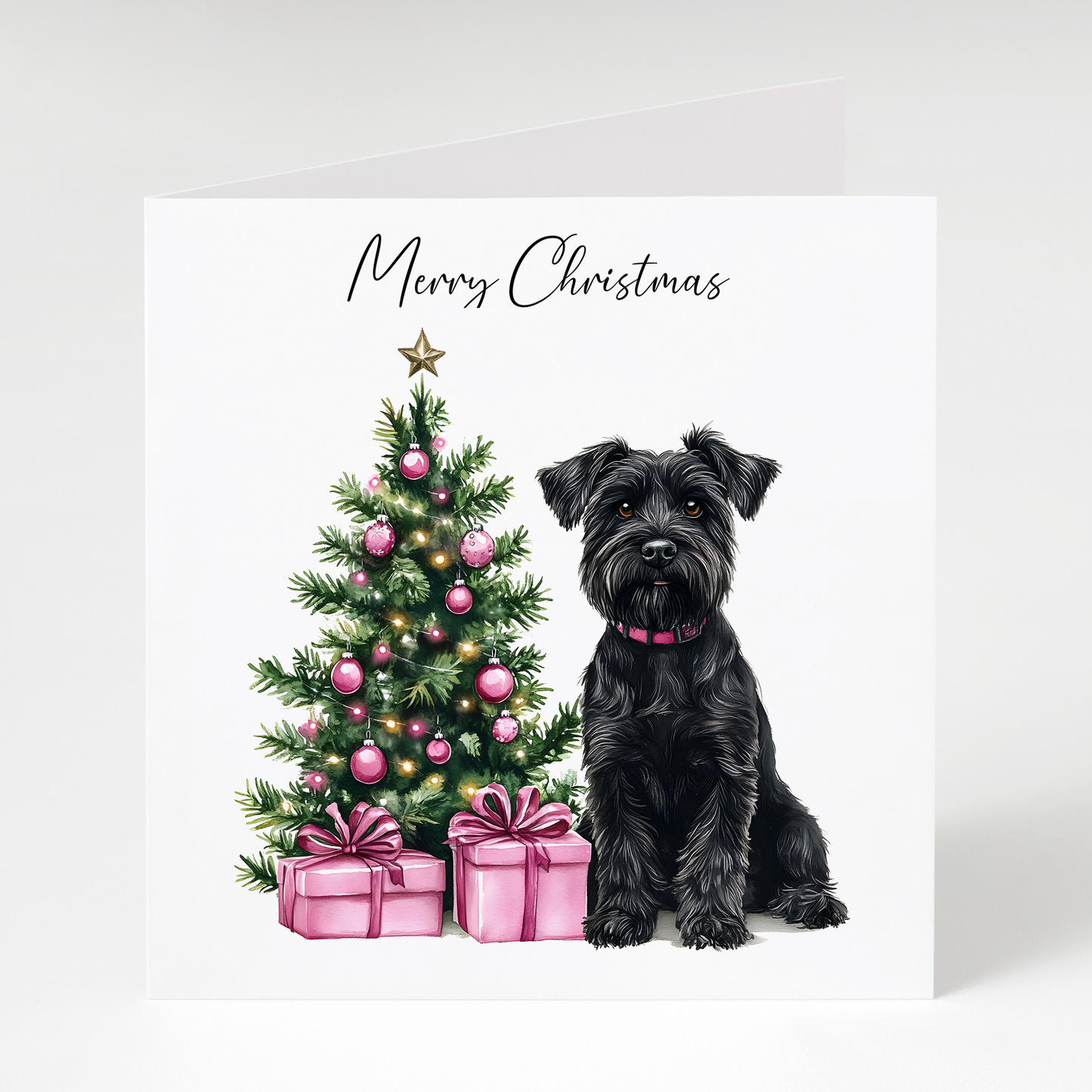 Black Miniature Schnauzer sitting beside a decorated Christmas tree with pink presents on a Christmas greeting card.