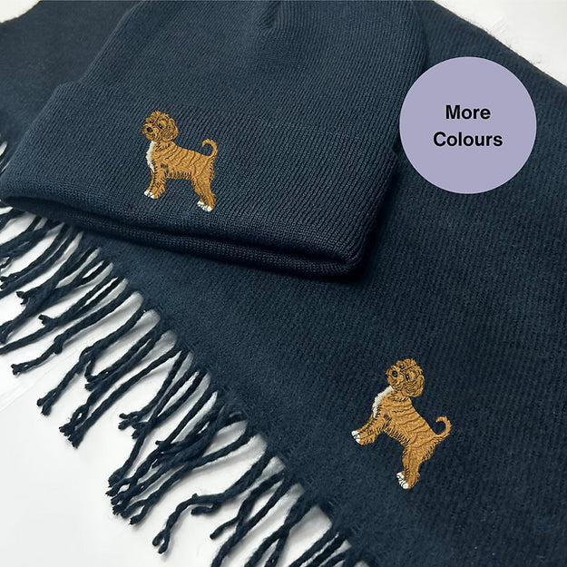 Navy beanie hat and tasselled scarf with golden Cockapoo embroidery on both pieces.