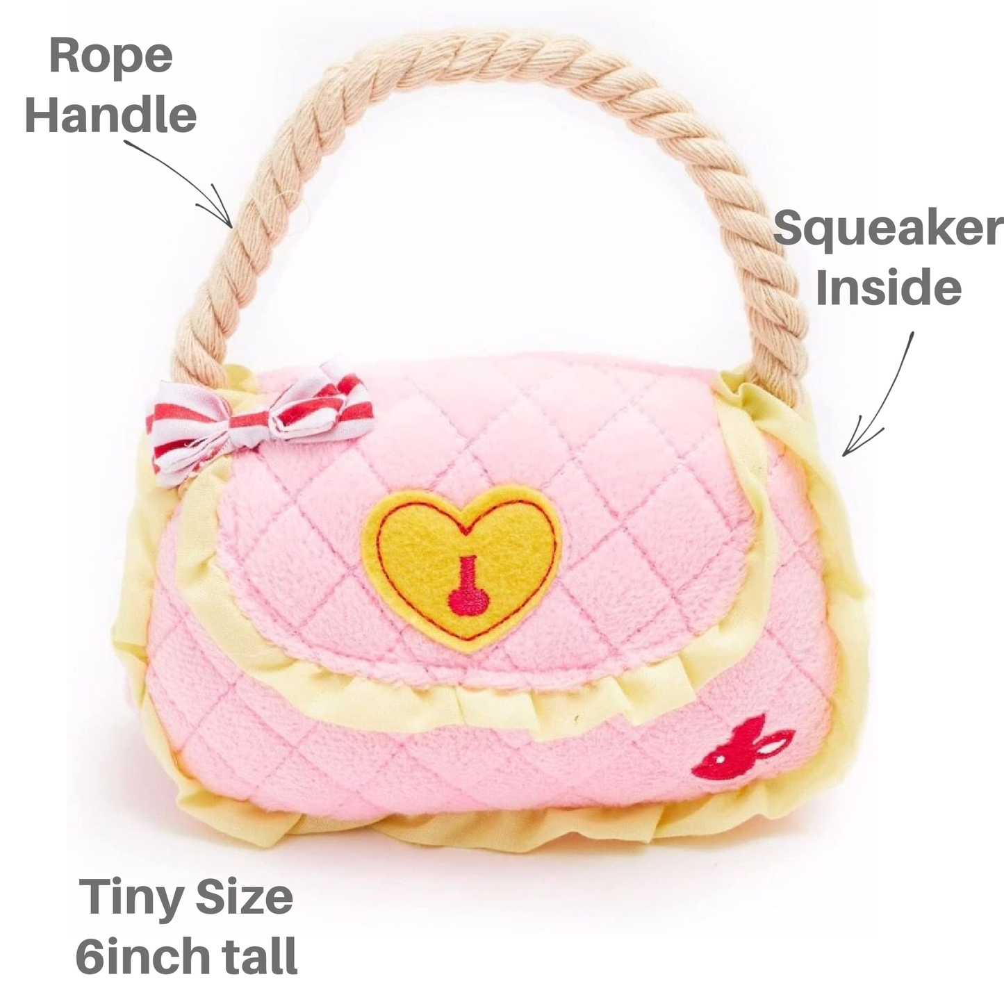Pink pet toy shaped like a handbag with a heart design, featuring a rope handle and squeaker inside.