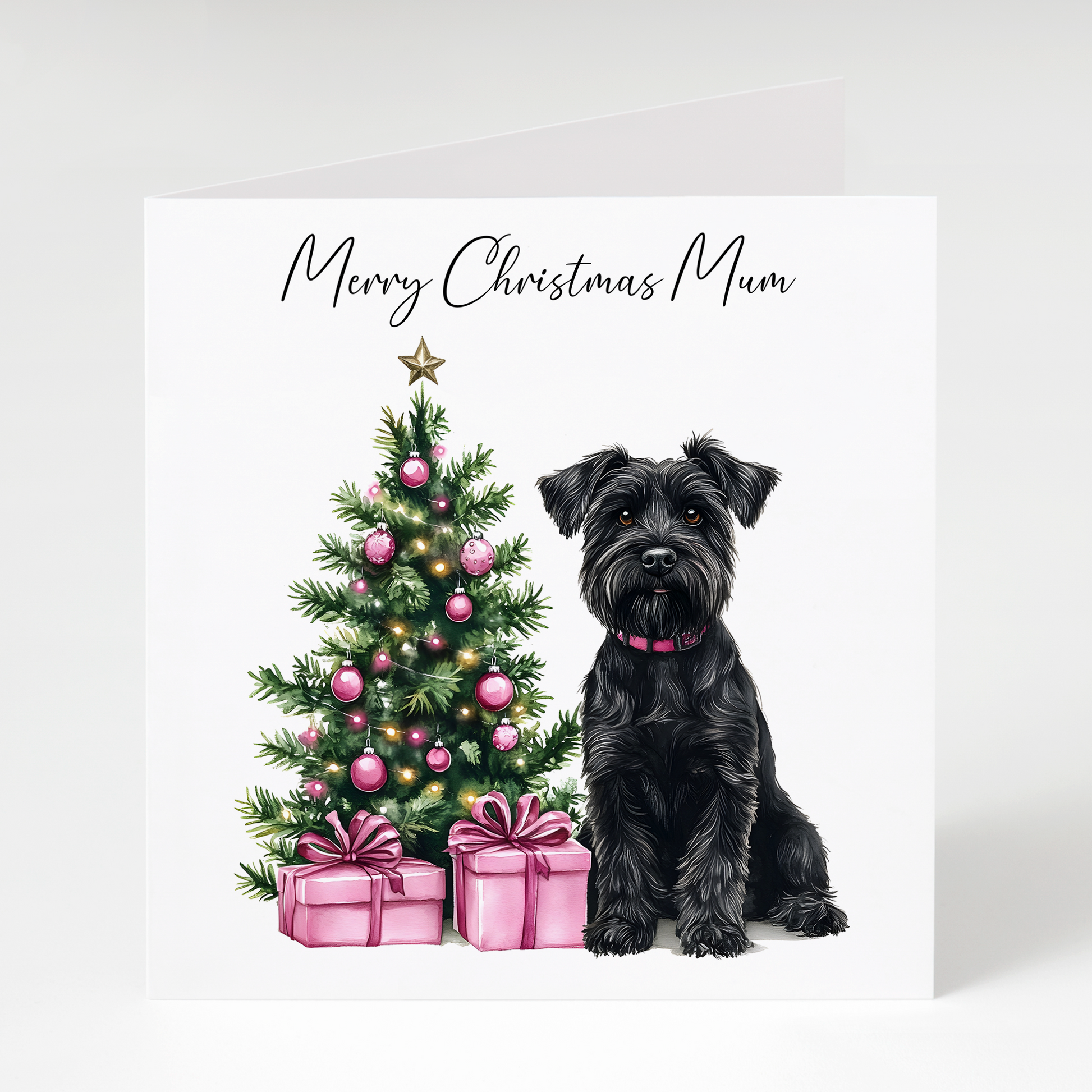 Black Miniature Schnauzer sitting beside a decorated Christmas tree with pink presents on a Christmas card for Mum.