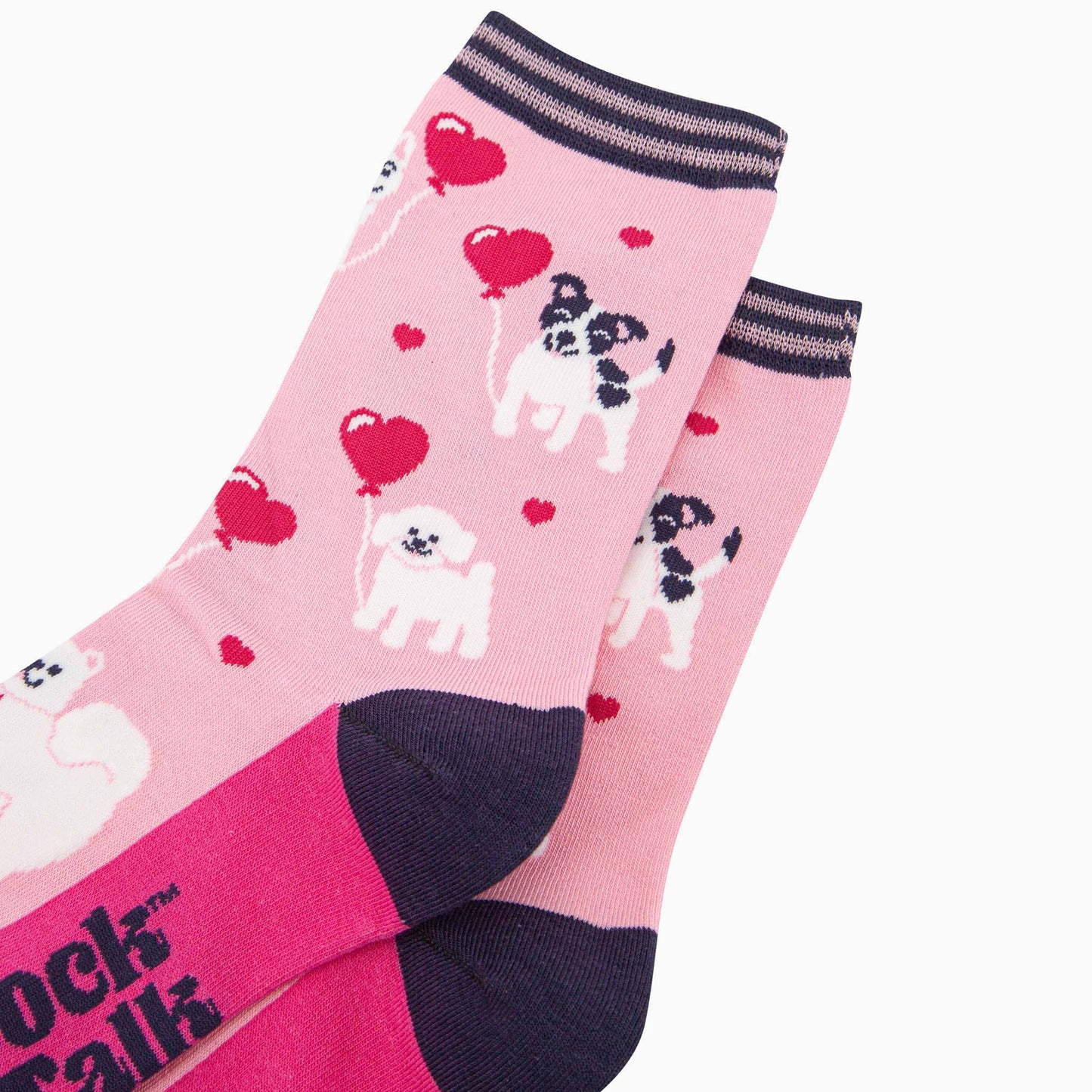 Pink socks with dog and heart patterns on a white background