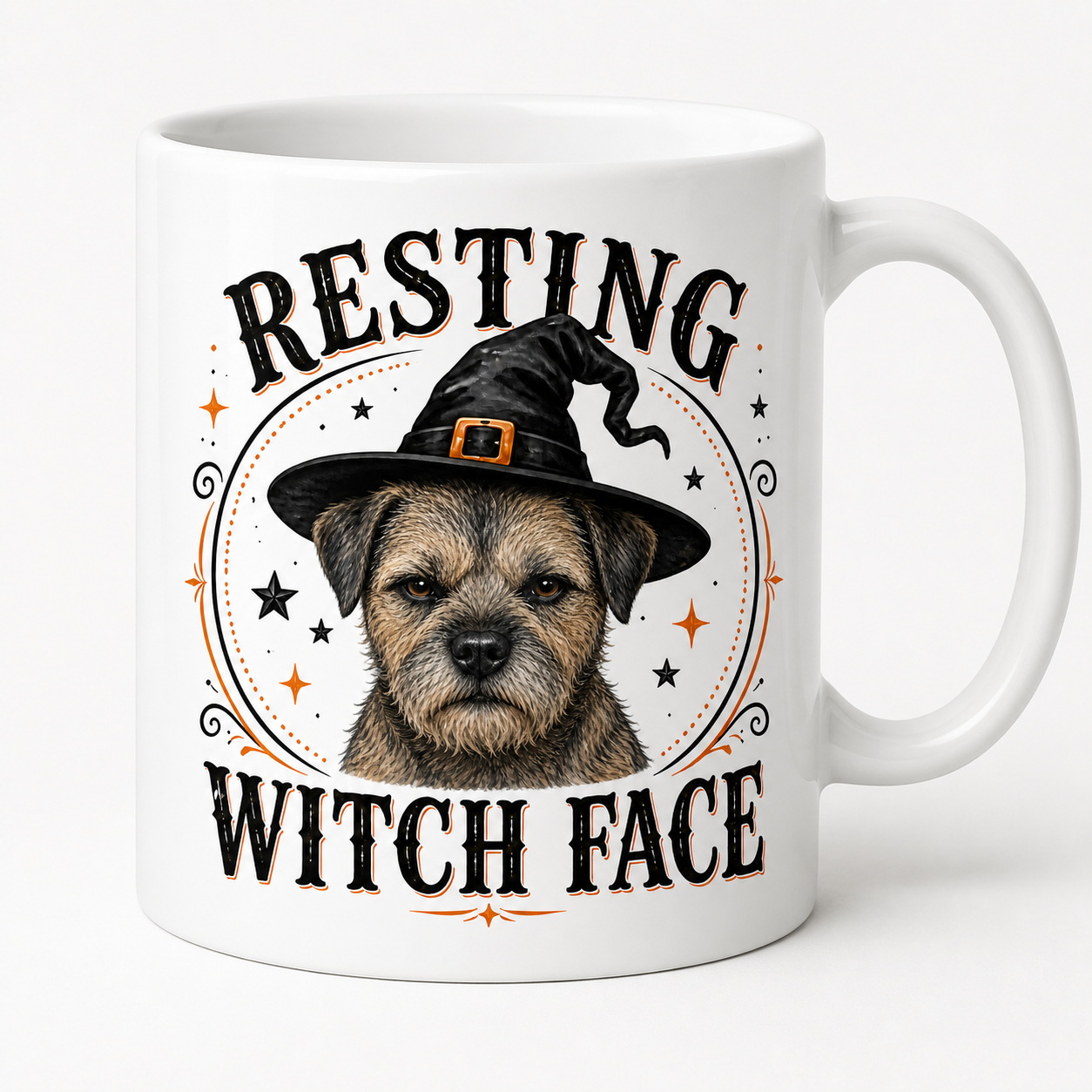 A white ceramic mug featuring a graphic of a border terrier with a witch hat and the text 'RESTING WITCH FACE' in black and orange lettering.