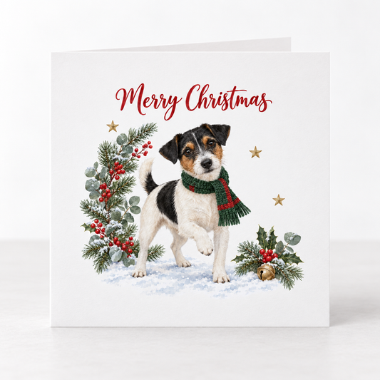 A square Christmas greeting card with a white background, featuring an illustration of a black, white, and tan dog wearing a green and red striped scarf, standing in snow with a green pine wreath and red berries. The text 'Merry Christmas' is written in red at the top.